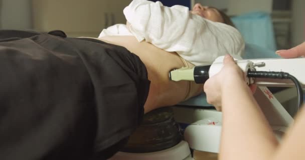 Extracorporeal shockwave therapy in urology. Cropped shot of lying woman patient, having ultrasound to determine kidney stones position before the lithotripsy procedure. — Stock Video