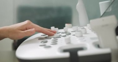 Modern tıbbi cihazın yakın çekim görüntüsü, ultrason makinesi tarayıcısı. Ultrason panelindeki düğmelere basan profesyonel kadın doktor sonografın eli