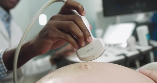 Fotografía de cerca del escáner de ultrasonido en manos de un médico afroamericano. Diagnósticos. Sonografía. Moderna máquina de ultrasonido en el fondo borroso — Vídeo de stock