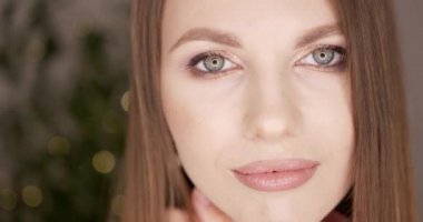 Kameraya bakan yeşil gözlü güzel kadın yüzü. Cilt bakımı veya kozmetik reklamları konsepti. Taze ve temiz ciltli güzel bir kadın model. Çıplak makyaj malzemesi. Stüdyoda.