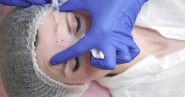 Güzellik uzmanının kozmetik kliniğinde genç ve güzel bir kadına güzellik iğnesi yaptığı yakın plan çekimler. Botoks Enjeksiyonu, Mezoterapi, Botulinum Terapisi, Biyolojik Evitalizasyon veya Yüz Derisinin Plazma Kaldırılması