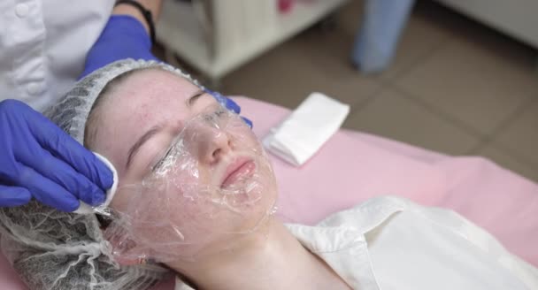 Професійний косметолог, який використовує ультразвуковий пристрій в руках і молода дівчина-підліток зі шкірою акне в сучасній косметологічній клініці. проведення процедури очищення шкіри . — стокове відео