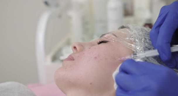Um plano de perto. revitalização da pele e mesoterapia. Médica cosmetologista realizando cirurgia biorevitalização injeções de uma mulher rosto pele. — Vídeo de Stock
