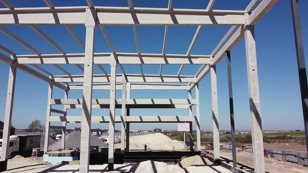 Concrete Building Construction Industrial Site. Reinforced Concrete Frame Of An Industrial Building. Camera Flight On A Construction Site. Beams With Steel Reinforcement From Above. Construction