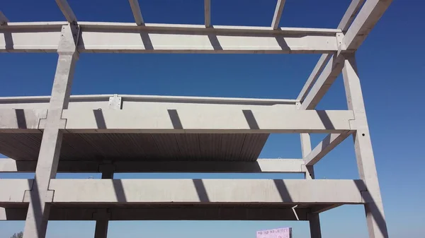 Concrete Building Construction Industrial Site. Reinforced Concrete Frame Of An Industrial Building. Camera Flight On A Construction Site. Beams With Steel Reinforcement From Above. Construction