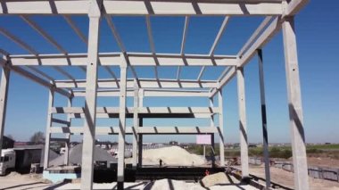 Beton İnşaat Endüstriyel Alanı. Bir sanayi binasının güçlendirilmiş beton çerçevesi. İnşaat alanındaki kamera uçuşu. Yukarıdan Çelik Güçlendirmeli Işınlar. İnşaat