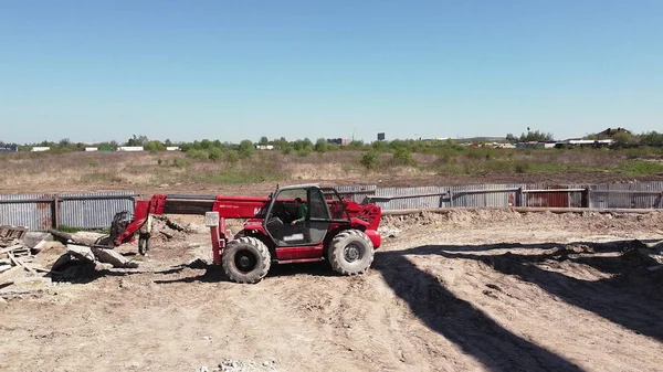 Lastaren laddar stenen. Frontlastare på byggarbetsplatsen. Bulldozer arbetar på byggarbetsplatsen. Grävmaskin på byggarbetsplats, personer arbetar på byggarbetsplats. — Stockfoto