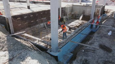 Mühendisler ve mimarlardan oluşan farklı bir ekiple Yeni Yapılanma Geliştirme Alanının Üzerinde Hava Uçuşu. İnşaat alanında çalışan işçiler beton yapıları güçlendirdi. Modern monolitik yapı
