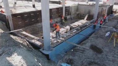 Mühendisler ve mimarlardan oluşan farklı bir ekiple Yeni Yapılanma Geliştirme Alanının Üzerinde Hava Uçuşu. İnşaat alanında çalışan işçiler beton yapıları güçlendirdi. Modern monolitik yapı