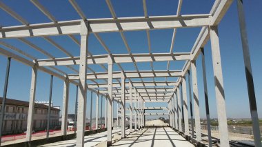 Bir sanayi binasının güçlendirilmiş beton çerçevesi. İnşaat alanındaki kamera uçuşu. Yukarıdan Çelik Güçlendirmeli Işınlar. Beton İnşaat Endüstri Alanı.