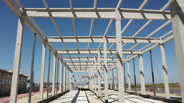 Reinforced Concrete Frame Of An Industrial Building. Camera Flight On A Construction Site. Beams With Steel Reinforcement From Above. Concrete Building Construction Industrial Site. — Stock Photo, Image