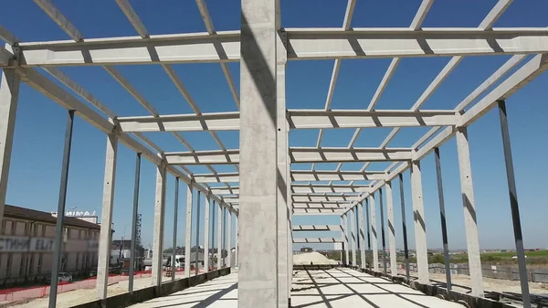 Struttura in cemento armato di un edificio industriale. Volo della telecamera in un cantiere. Travi con rinforzo in acciaio dall'alto. Costruzione di edifici in calcestruzzo sito industriale. — Foto Stock