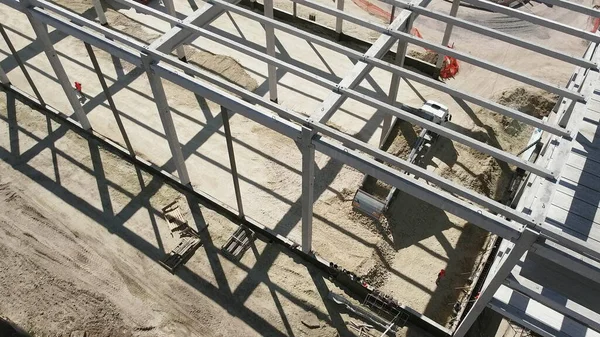 Struttura in cemento armato di un edificio industriale. Volo della telecamera in un cantiere. Travi con rinforzo in acciaio. Autocarro con cassone ribaltabile scarica sabbia in costruzione. Vista aerea. Scarico del suolo — Foto Stock