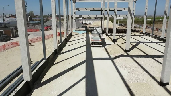 LKW fährt auf dem Gebiet des Neubaus. Stahlbetonrahmen des Neubaus. Ein Lastwagen mit abgedecktem Anhänger brachte Sand oder Erde zur Baustelle. Lieferung von Material — Stockfoto