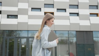 Beyaz kadın ofis çalışanı dosyalarla işini aceleye getiriyor. Güzel kadın iş işçisi. İş, aktivite. İş kadını ya da kız öğrenci aceleyle meşgul, kadın işe geç kalıyor.