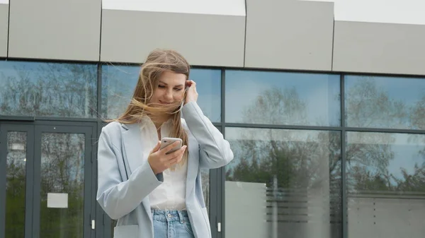 Une jeune fille chanceuse regarde le téléphone et voit le message de bonnes nouvelles au téléphone. La femme se réjouit et rit, saute. Gagnant et moment de victoire de loterie, vente et réductions, offre spéciale get concept — Photo