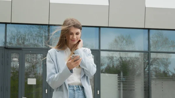 Une jeune fille chanceuse regarde le téléphone et voit le message de bonnes nouvelles au téléphone. La femme se réjouit et rit, saute. Gagnant et moment de victoire de loterie, vente et réductions, offre spéciale get concept — Photo