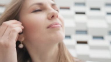 Genç iş kadını, akıllı telefondan müzik listesinin keyfini çıkarıyor. Modern kulaklıklarla, iyi ses ve müzik setleriyle sokakta yürümekten keyif alıyor. Güzel iş kadını müzikten hoşlanıyor.