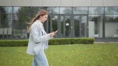 Sokakta yürürken e-posta kutusuna bakarken alışveriş için indirim alan mutlu genç kadın. Kadın akıllı telefon kullanarak online alışveriş için kredi kartı numarası giriyor.