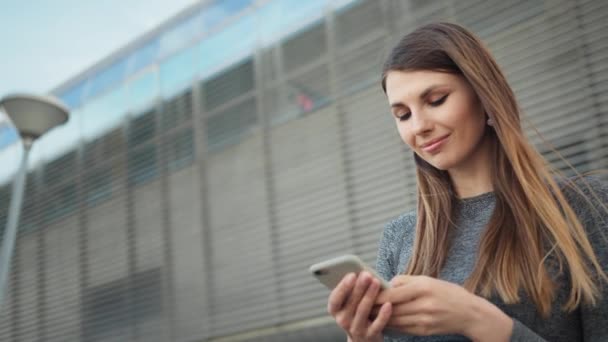 Detailní záběr mladé krásné sportovní Fitness Girl drží chytrý telefon v rukou, pomocí Fitness aplikace. Modern City Shooting On the Street. Portrét žena při pohledu na smartphone při běhu venku — Stock video