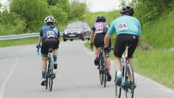 Sykling maraton. Langsom bevegelse av et sykkelhjul. Sporer bilder av en gruppe syklister på landeveien. CU, foto foran av en syklist på veien – stockfoto