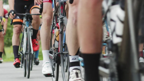 Et svakt fokusbilde av syklister med lavere kropper mens de sykler. Sykkelhjulet snurrer. Sykkelhjulrotasjon. Sykkeltrening. Sport sunn livsstil. – stockfoto