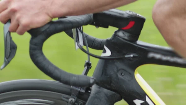 Lähikuva pyörän kaarevasta ohjauspyörästä, pyöräilijän vaihtonopeuden käsistä ajon aikana. — kuvapankkivalokuva