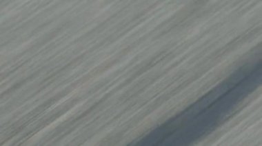 Pürüzsüz yarış turbo araç ve motosiklet, yol yüzeyindeki arka planda hız üstündeler. Soyut bulanık duvar kağıdı konsepti. 4K video kaydı. Hız yolu uçuşu, kusursuz döngü özelliği var..