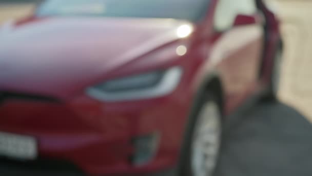 Primer plano del vendedor femenino que presenta las llaves del coche eléctrico rojo al cliente masculino. Desenfoque de fondo de auto de lujo. Concepto de acuerdo exitoso. Vendedora dando llaves de coche eléctrico a cliente masculino — Vídeos de Stock