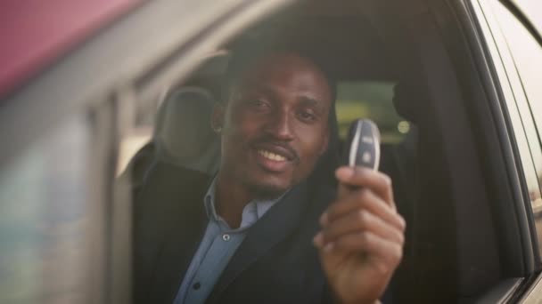 Afro-Amerikaanse zakenman in pak zittend in zijn luxe elektrische auto met sleutels in handen. Knappe man lijkt tevreden met een succesvolle aankoop. Eco voertuig. Nieuwe elektrische auto met toetsen in de hand — Stockvideo