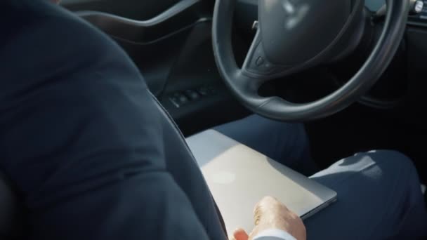 African american man in business suit sitting on drivers seat of modern electric car and typing in wireless laptop. Busy person with portable computer. Man turns a modern laptop in the car — Stock Video