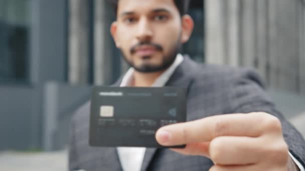 Επιτυχημένος Άραβας επιχειρηματίας που στέκεται σε εξωτερικούς χώρους και κατέχει σύγχρονο smartphone με τραπεζική κάρτα. Γενειοφόρος με επίσημα ρούχα κάνει αγορές στο διαδίκτυο. Αραβας δείχνει μαύρη πιστωτική κάρτα — Αρχείο Βίντεο