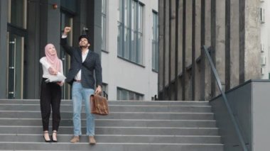 Mutlu Müslüman erkek ve kadın, Yöneticiler bitirdikleri iş için sevinçle kağıtlarını fırlatırlar. Başarılı iş arkadaşları iş amaçlarına ulaşmayı kutluyor. Başarılı iş kavramı. Yavaş çekim