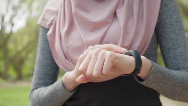 Runner vérifiant le pouls sur la montre intelligente lors de l'entraînement en cours d'exécution. Runner Check Pulse On Fitness Bracelet.Girl à l'aide de Smart Band.Fit femme vérification du temps sur Smartwatch après jogging.Athlete fille utiliser montre intelligente — Video