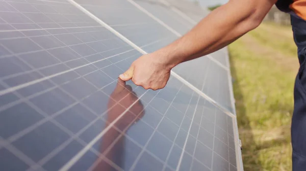 Lähellä nuori insinööri käsi tarkistaa auringon toimintaa ja puhtaus aurinkosähkö aurinkopaneelit auringonlaskun. Nykyaikaisen aurinkosähköakun lähikuva. — kuvapankkivalokuva