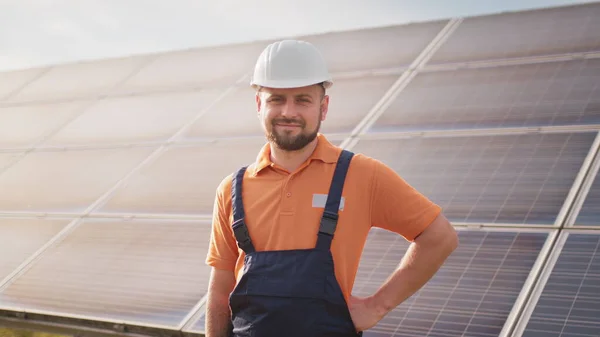 Portrett av selvsikker ingeniør i solcelleindustrien. Personalet er trygge på installasjon av solcellepaneler. Lukk opp portrettet av mannlig arbeider i beskyttelseshjelm som står ved solcellepanelet – stockfoto