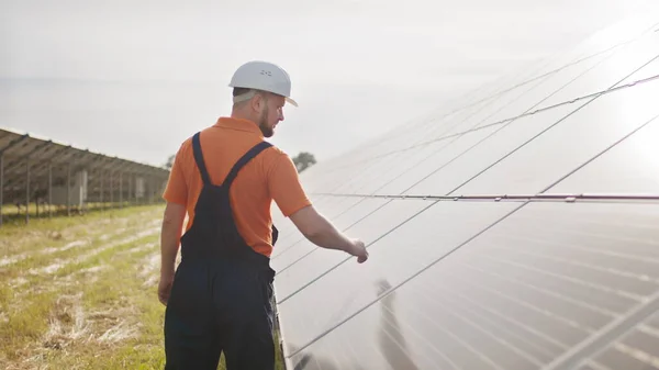 Bistandstekniker i uniform kontrollerer solcellepanelenes virkemåte og effektivitet. Elektrisitet, økologi. Solcellepaneler. Grønn energi – stockfoto