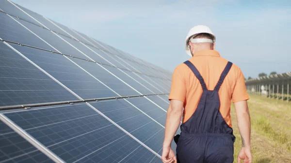 可持续的绿色能源工作，太阳能电池板技术员与太阳能电池板一起工作。穿着制服的技术人员正在检查光电太阳能电池板的运行情况和效率 — 图库照片