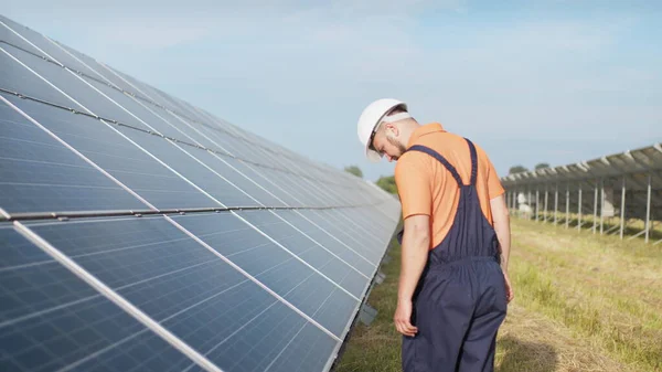 Bærekraftige grønne energijobber, solpaneltekniker som arbeider med solcellepaneler. Bistandstekniker i uniform kontrollerer solcellepanelers virkemåte og effektivitet – stockfoto