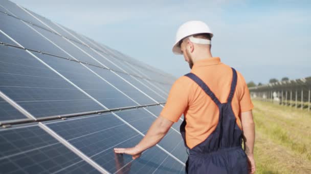 Duurzame groene energie banen, zonnepaneel technicus werken met zonnepanelen. Assistentie technisch medewerker in uniform controleert de werking en efficiëntie van fotovoltaïsche zonnepanelen — Stockvideo