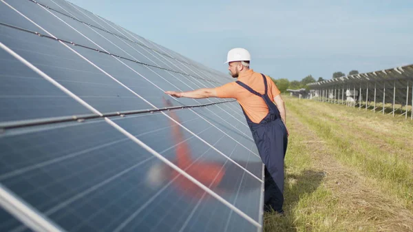 Ung ingeniør sjekker solens drift og renhet på solcellepaneler. Konseptet fornybar energi. Konsept for utvikling av solstasjoner og grønn energi – stockfoto