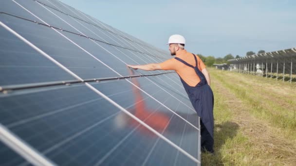 Νέος μηχανικός ελέγχει τη λειτουργία του ήλιου και την καθαριότητα των φωτοβολταϊκών ηλιακών συλλεκτών. Έννοια ανανεώσιμη ενέργεια. Έννοια της ανάπτυξης ηλιακών σταθμών και της πράσινης ενέργειας — Αρχείο Βίντεο
