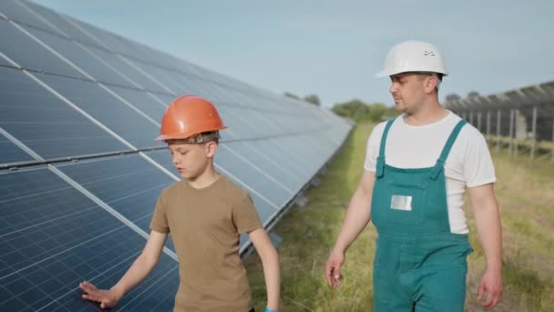 Ingenieur vader legt zijn zoontje een operatie en uitvoering van fotovoltaïsche zonnepanelen uit. Concept van ecologische hernieuwbare energie en kwaliteitstijd van het gezin. Concept: hernieuwbare energie — Stockvideo