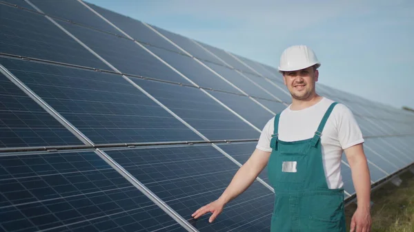 Virkapukuinen tekninen työntekijä tarkistaa aurinkosähköpaneelien toiminnan ja tehokkuuden. Insinööri korjaus ja huolto aurinkosähkö. Vihreän energian hanke on käynnissä. — kuvapankkivalokuva