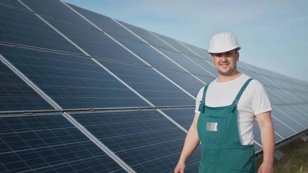 Bistandstekniker i uniform kontrollerer solcellepanelenes virkemåte og effektivitet. Reparasjon og vedlikehold av solcelleanlegg. Prosjektet Grønn energi pågår. – stockfoto