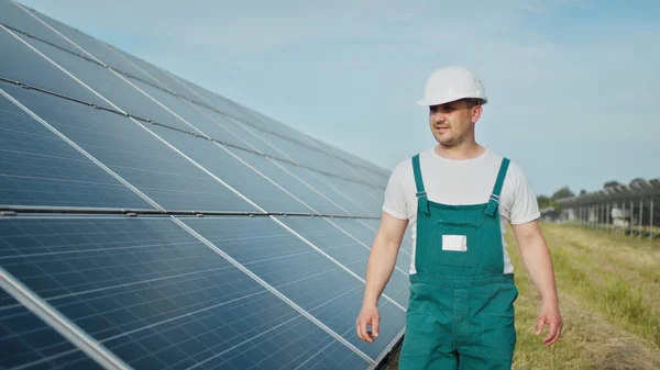 Ingeniør sjekker solens drift og renhet på solcellepaneler. Konseptet fornybar energi. Hvit mann i hjelm som undersøker solcellepaneler. Begrepet grønn energi – stockfoto