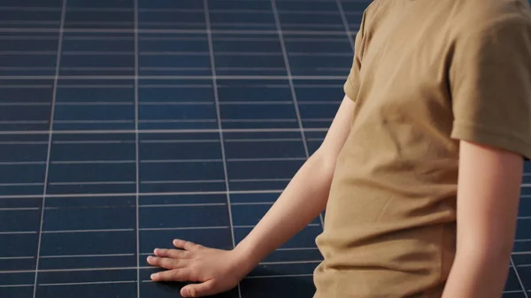 Ragazzino con un casco protettivo in una centrale solare. Il concetto di bambini ed energie verdi. Bambini per energia pulita. Sparatoria ad una centrale solare. Fattoria ecologica. Centrale solare — Foto Stock