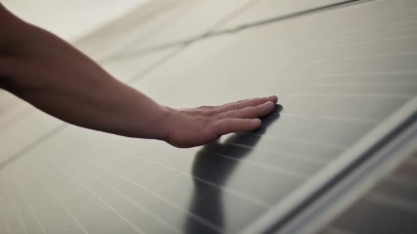 Gros plan d'un jeune ingénieur main vérifie le fonctionnement du soleil et la propreté des panneaux solaires photovoltaïques sur un coucher de soleil. Concept.renewable energy, technology, electricity, service, green, future. — Video