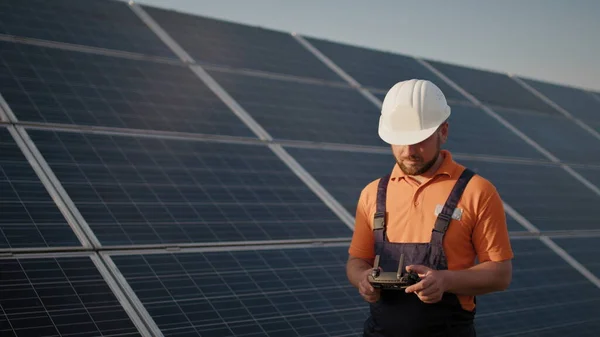 산업 전문가들 이 태양광 발전소에서 헬멧을 쓰고 드론을 조종하고 있습니다. 태양광 패널 배열 설치. 기술 과 생태계. 새로운 기술 — 스톡 사진