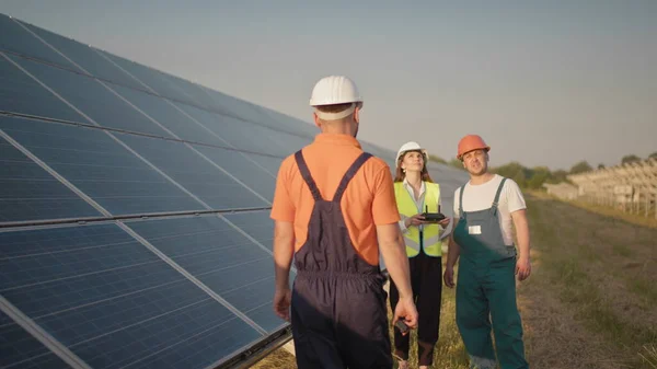 彼の同僚と投資家が赤外線スキャナー、ドローンで太陽光発電所をチェックしている間、太陽光発電所の従業員はウォーキートーキーで話します。太陽光発電パネル設置 — ストック写真